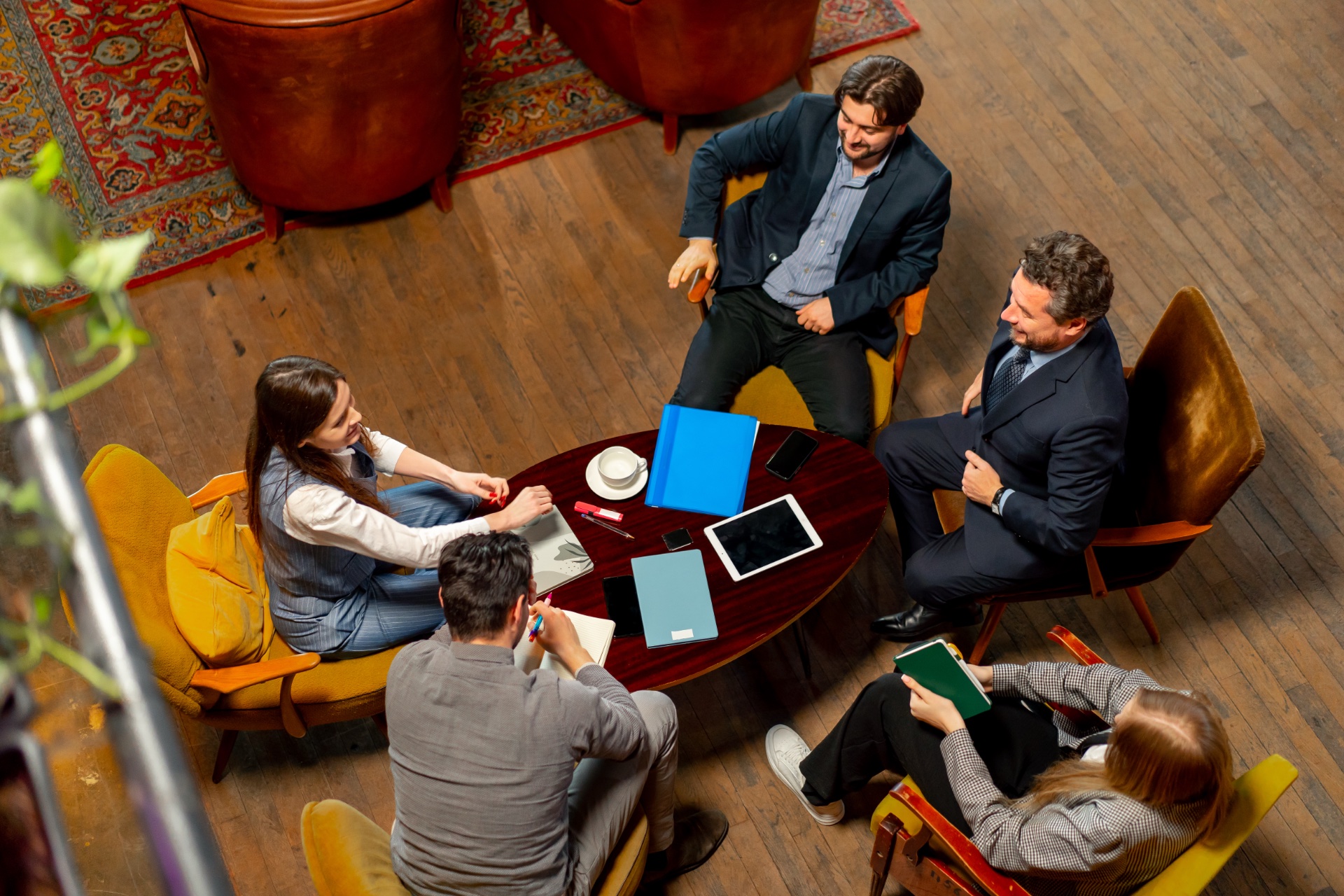top shot in a large beautiful hall office employees sitting on yellow chairs discuss a deal