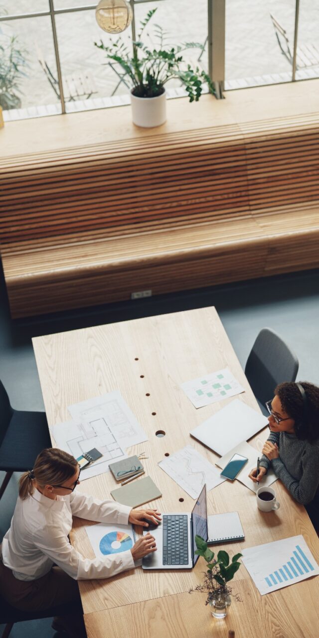 Top view of office workers discussing new project during working day in coworking Woman office worker discussing new project with colleague in coworking. High quality photo